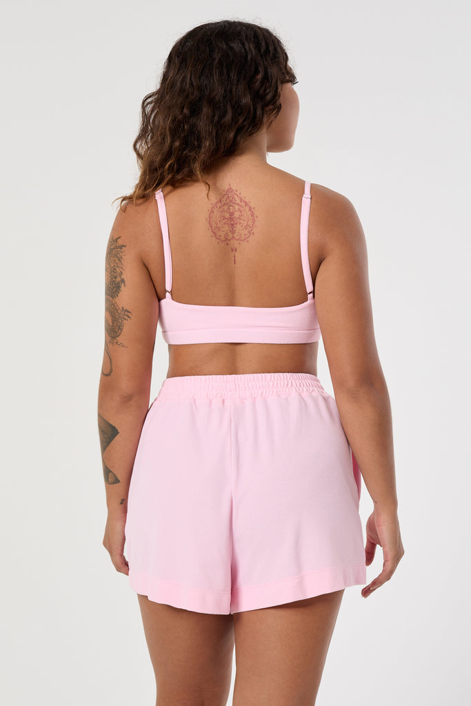 Lightweight, breathable light pink bralette with adjustable straps and removable padding. Perfect for lounging or errands, back view