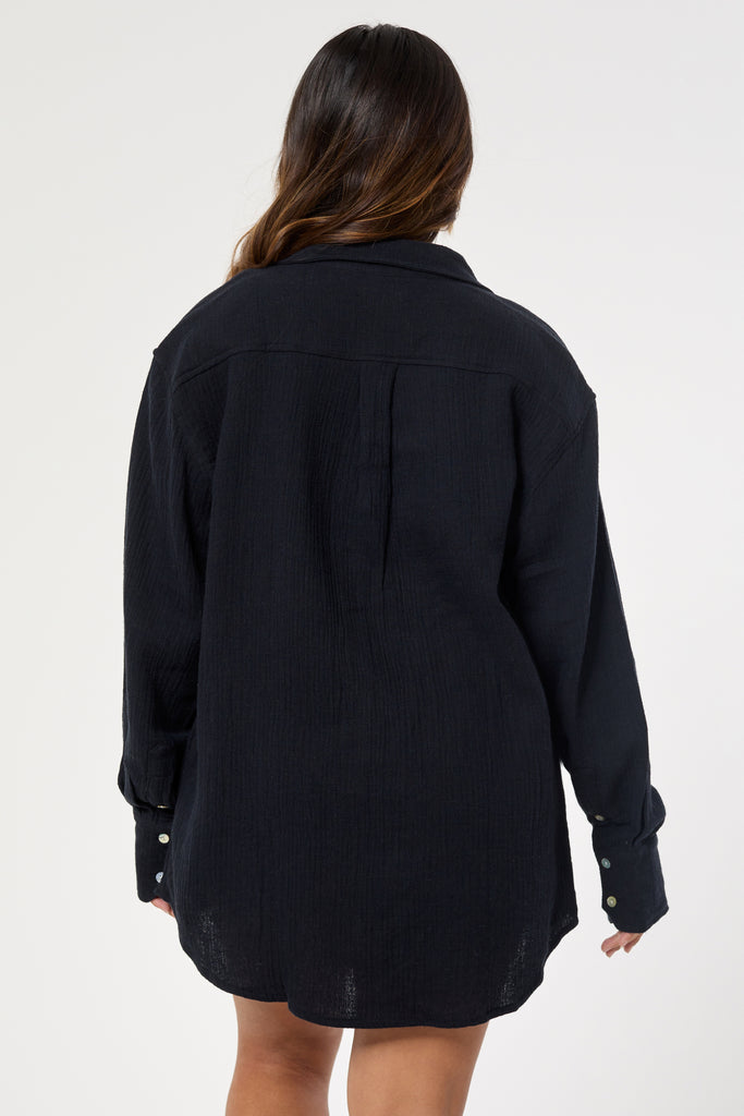 Oversized Ida black shirt with pearl buttons, long cuffs, and rounded hem. Made from breathable hemp and organic cotton back view