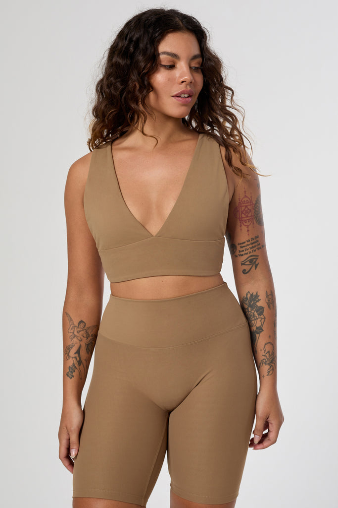 Light brown deep V-neck low-impact support with a seamless fit, removable padding for all-day comfort and style.