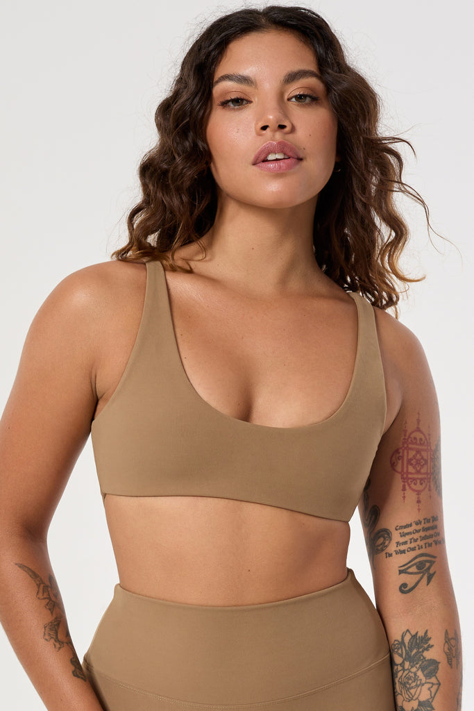 Light brown two in one reversible sports bra, medium-impact support with seamless fit, under-bust support, and removable padding close up