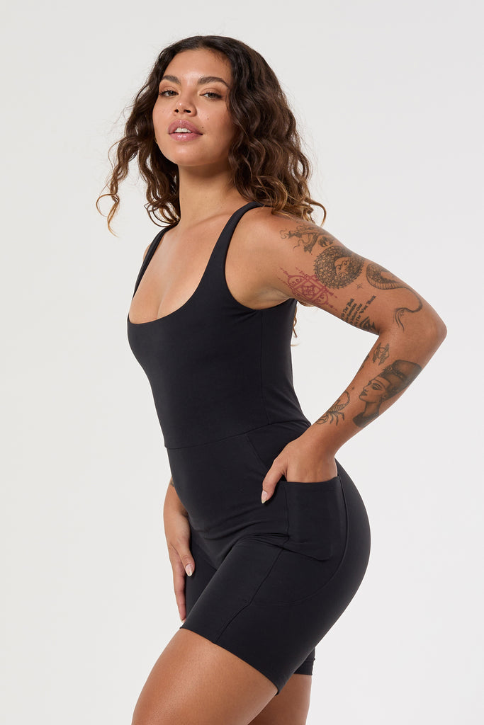 Black onesie with a cute square neckline, low back, high waist seam, and double side pockets. Perfect for every activity, side view