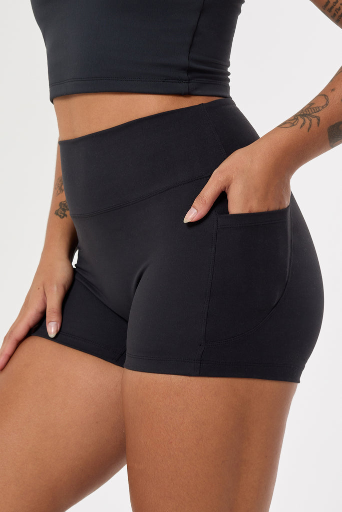 Cute black shorts: mid-high waisted with side pockets, V-shaped back seam, squat proof, no front seam, and double-layered waistband close up