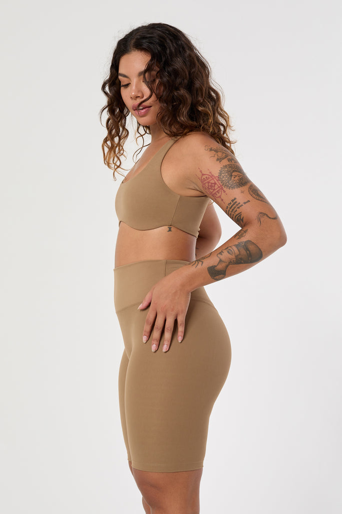 Mid-high waisted Light brown shorts with a V-shaped back seam for a flattering lift. Squat proof, no front seam, and double-layered waistband, side view