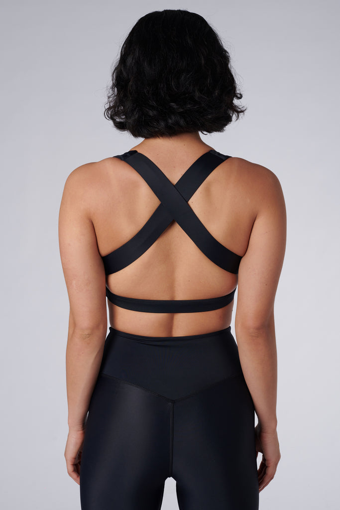 Black, medium to high impact support with removable padding, strong elastic cross back straps, and adjustable gold-hook closure, back view