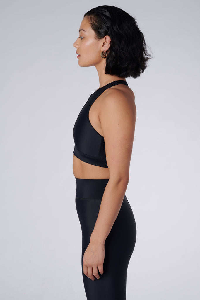 Easy to wear front zipped black crop top with low-impact support, removable padding and in-built sports bra, side view