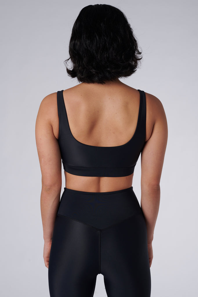 Black classic sports bra with mid to high impact support, seamless fit, removable padding, back view