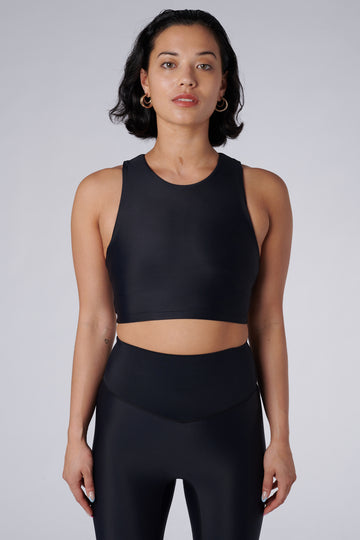 Award-winning black crop top with a flattering cut, high neckline for coverage, and in-built sports bra. Medium impact support, perfect for day wear