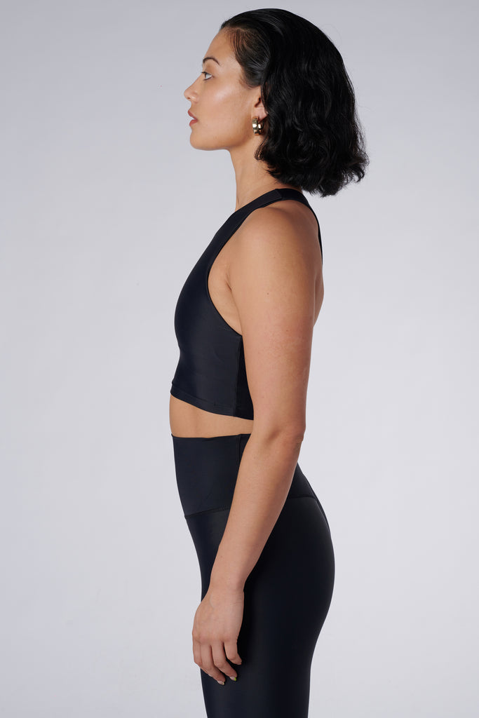 Award-winning black crop top with a flattering cut, high neckline for coverage, and in-built sports bra. Medium impact support, perfect for day wear, side view