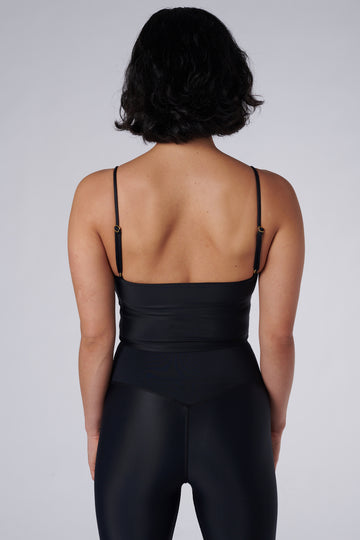 Black crop top with inbuilt bra for low-impact activities, seamless fit, removable padding, and adjustable straps. Comfortable for work or on the go, back view