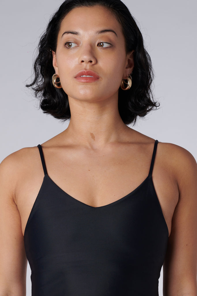 Black crop top with inbuilt bra for low-impact activities, seamless fit, removable padding, and adjustable straps. Comfortable for work or on the go, close up