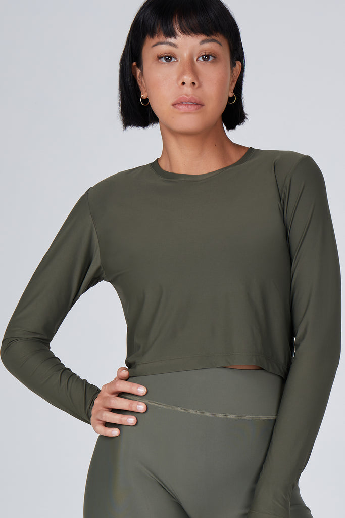 Ultra-lightweight, quick-drying long sleeve olive green crop top that fits like a second skin for comfort and UV protection close up