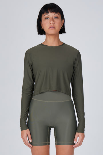 Ultra-lightweight, quick-drying long sleeve olive green crop top that fits like a second skin for comfort and UV protection.