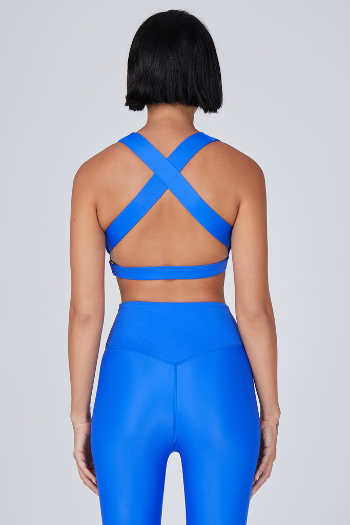 Medium blue, medium to high impact support with removable padding, strong elastic cross back straps, and adjustable gold-hook closure, back view