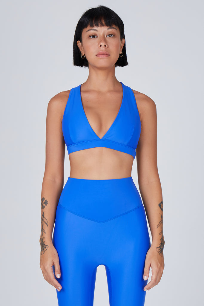 Mid blue, medium to high impact support with removable padding, strong elastic cross back straps, and adjustable gold-hook closure, front view