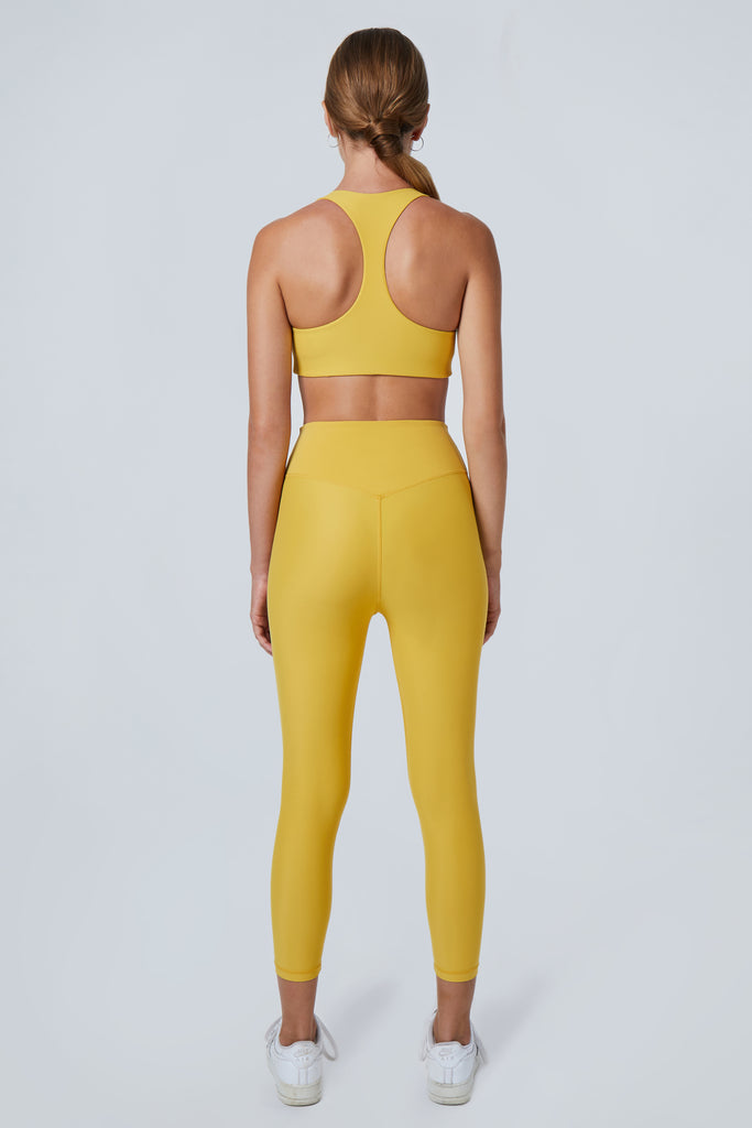 Super soft yellow high-waisted 7/8 leggings without a front seam for all-day comfort. Perfect for non abrasive sports and everyday wear, back view