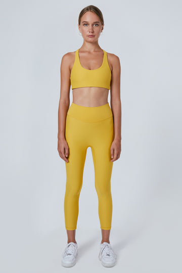 Super soft yellow high-waisted without a front seam for all-day comfort. Perfect for non abrasive sports and everyday wear, front view