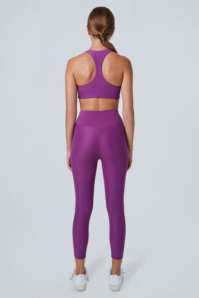 Super soft purple high-waisted 7/8 leggings without a front seam for all-day comfort. Perfect for non abrasive sports and everyday wear, back view