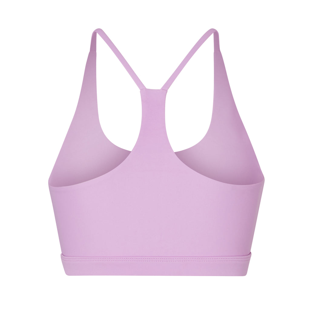 Classic racerback sports bra in light pink with seamless fit and removable padding. Perfect for light workouts and everyday wear, ghost image back view