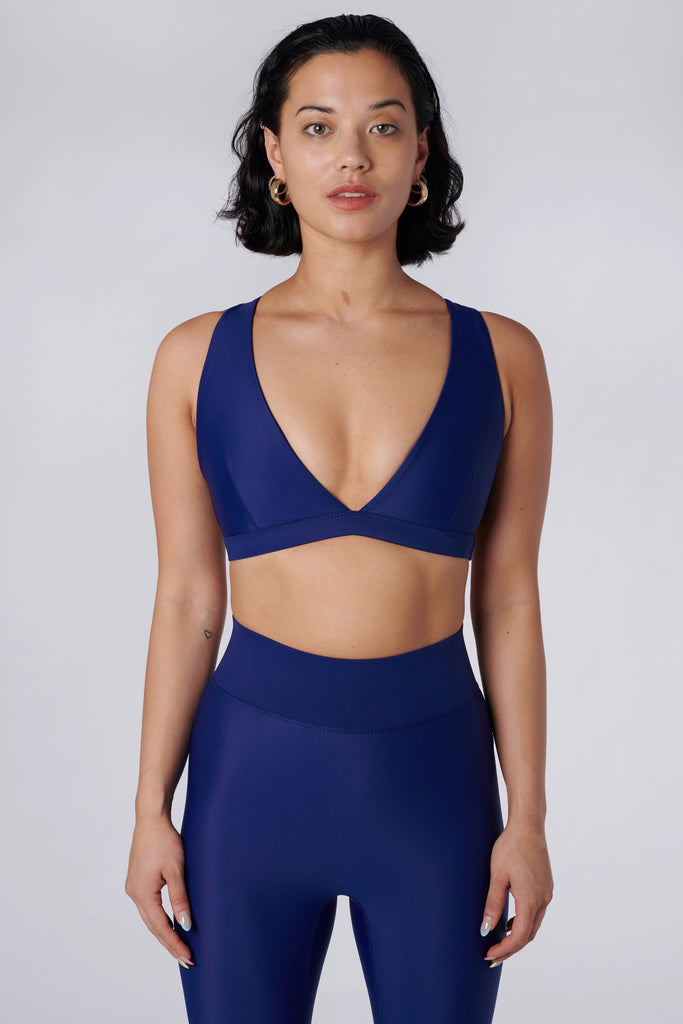 Navy blue, medium to high impact support with removable padding, strong elastic cross back straps, and adjustable gold-hook closure, front view