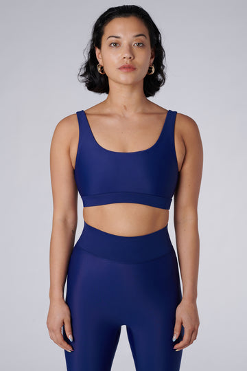 Navy blue classic sports bra with mid to high impact support, seamless fit that holds everything in place, removable padding, front view