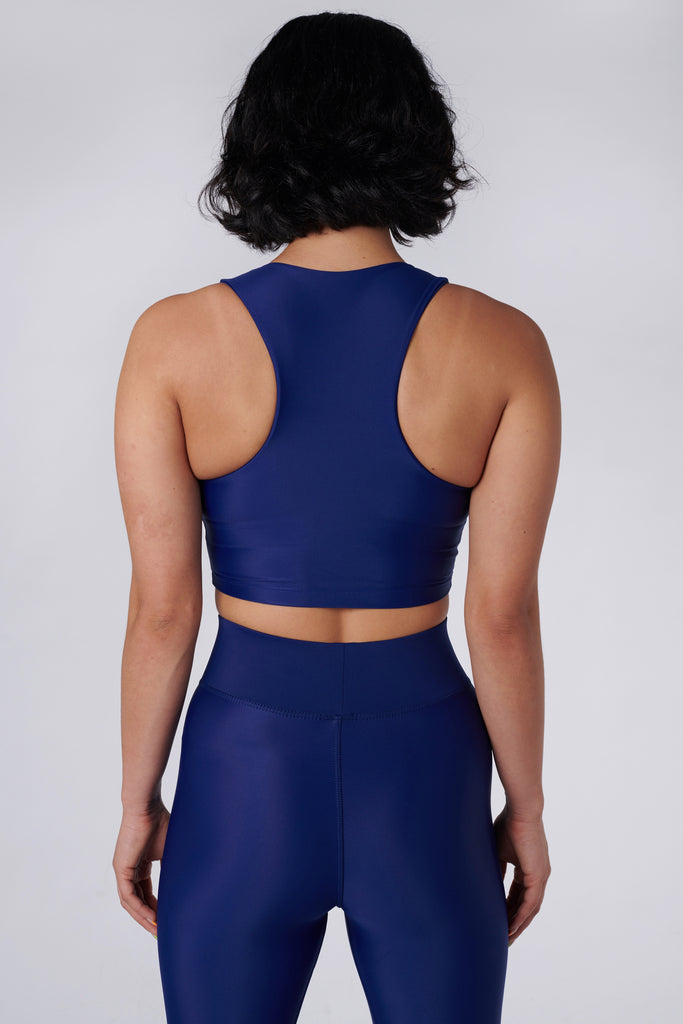 Award-winning navy blue crop top with a flattering cut, high neckline for coverage, and in-built sports bra. Medium impact support, perfect for day wear, back view