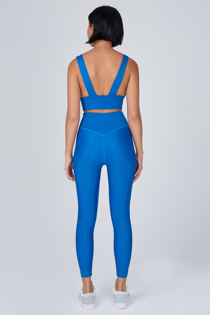 Versatile mid blue 7/8 compressive leggings that fit like a glove and stay put during workouts. Squat proof and no front seam for ultimate comfort back view