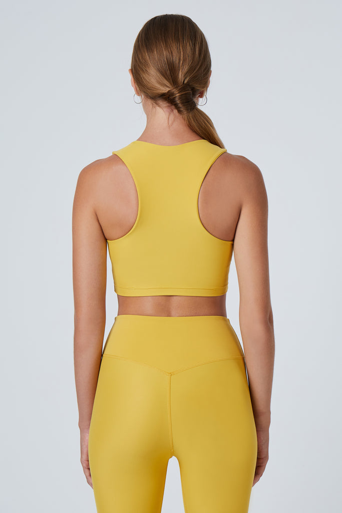 Award-winning yellow crop top with a flattering cut, high neckline for coverage, and in-built sports bra. Medium impact support, perfect for day wear, back view