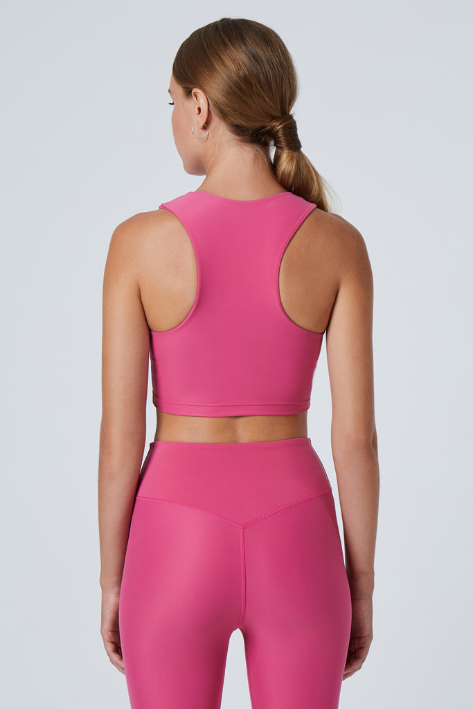 Award-winning pink crop top with a flattering cut, high neckline for coverage, and in-built sports bra. Medium impact support, perfect for day wear, back view