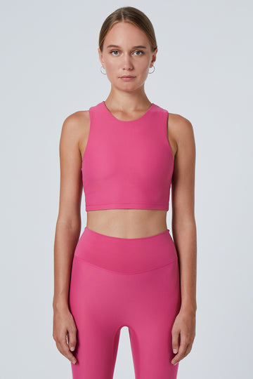 Award-winning pink crop top with a flattering cut, high neckline for coverage, and in-built sports bra. Medium impact support, perfect for day wear