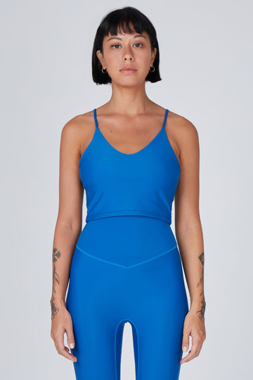 Mid blue crop top with inbuilt bra for low-impact activities, seamless fit, removable padding, and adjustable straps. Comfortable for work or on the go.