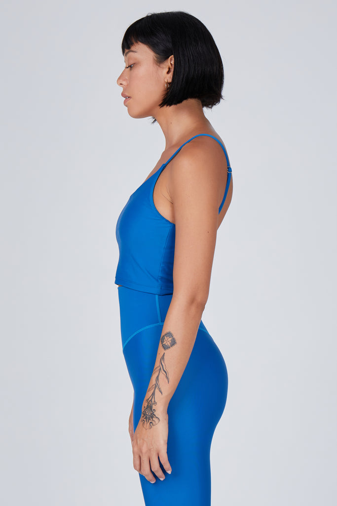 Mid blue crop top with inbuilt bra for low-impact activities, seamless fit, removable padding, and adjustable straps. Comfortable for work or on the go, side view